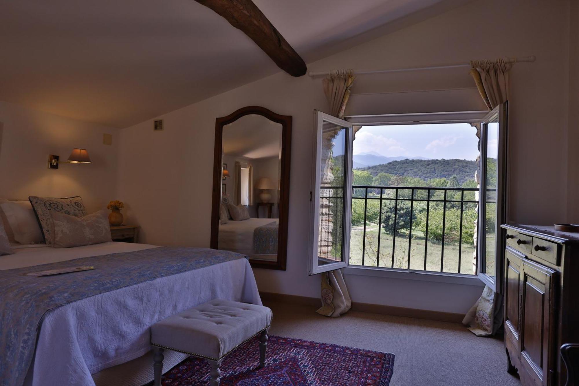 Peaceful empty French countryside hotel bedroom with rustic wooden beams